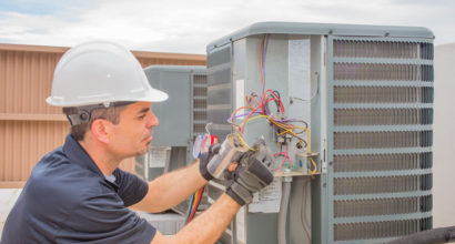 85556380 - hvac technician checking capacitor on air conditioner
